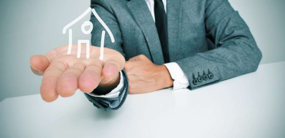 homme tenant une maison dans sa main