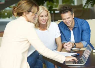 agent immobilier et un jeune couple discutant de leur gestion locative