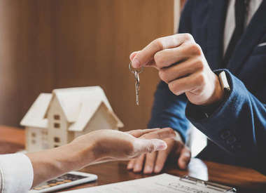 agent immobilier donnant des clés au futur propriétaire